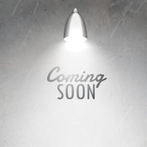 coming soon text placed under glowing lamp on gray textured wall